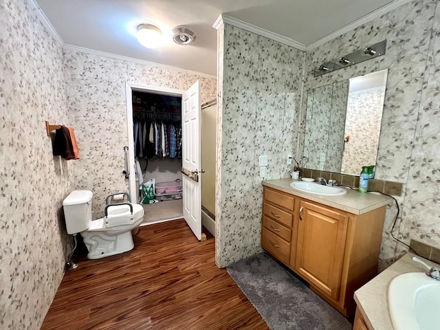 bathroom with toilet, vanity, ornamental molding, and hardwood / wood-style flooring