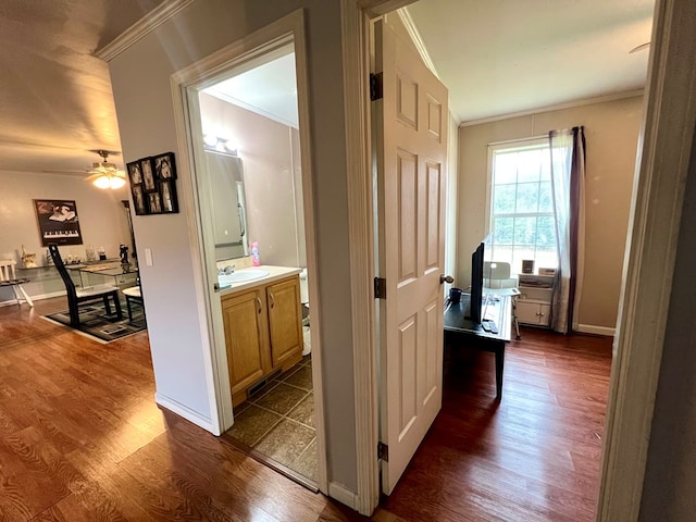 hallway with ornamental molding, dark wood-type flooring, and sink