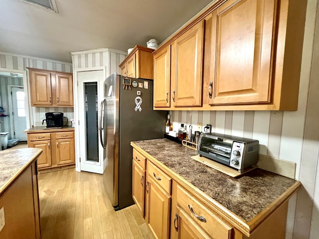 kitchen featuring stainless steel fridge, crown molding, and light hardwood / wood-style flooring