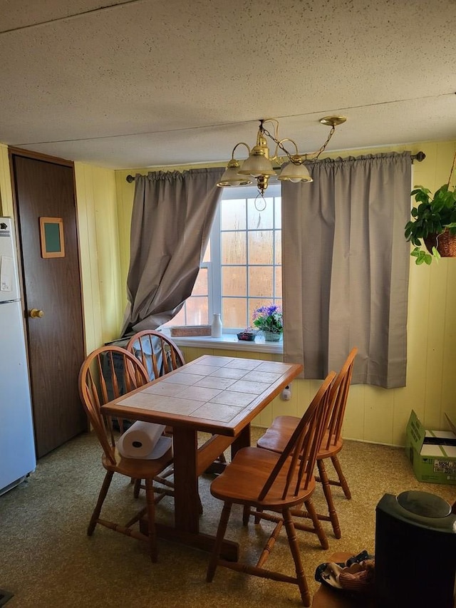 carpeted dining area featuring a textured ceiling