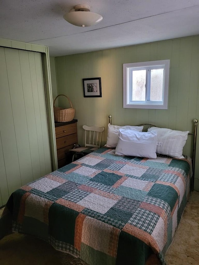 carpeted bedroom with wood walls