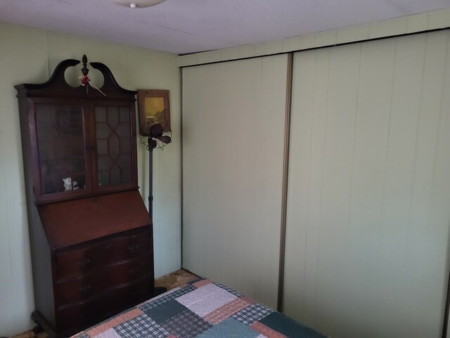 bedroom featuring wooden walls