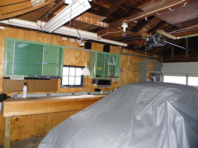 garage with a garage door opener and wood walls