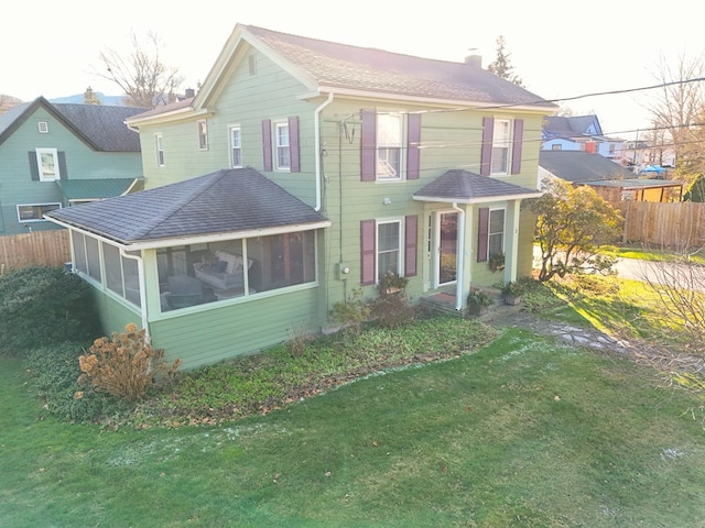 view of front of property featuring a sunroom and a front lawn