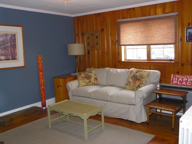 living room with hardwood / wood-style floors, crown molding, and wooden walls