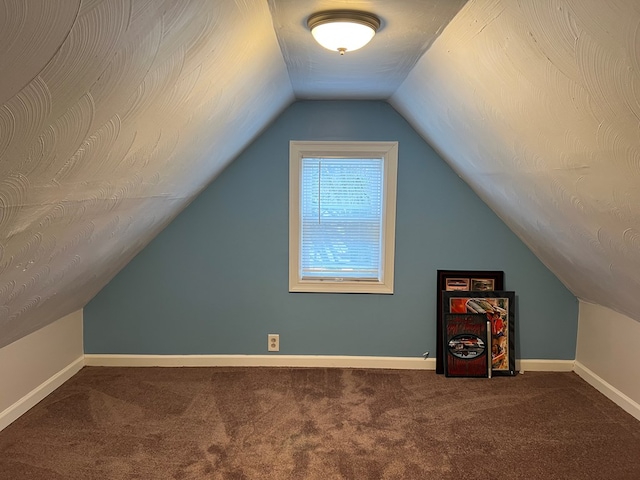 additional living space featuring carpet floors and vaulted ceiling