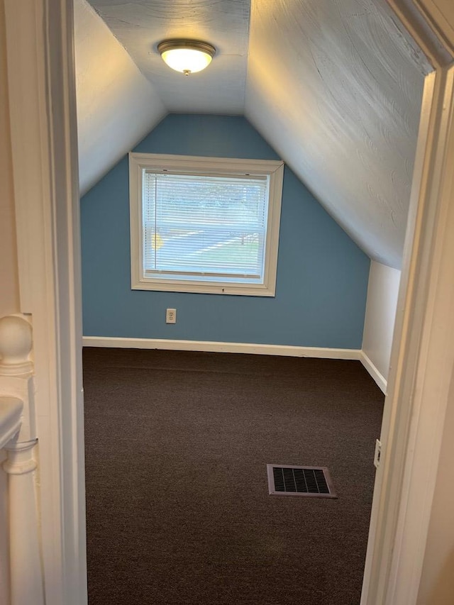 bonus room with carpet floors and vaulted ceiling