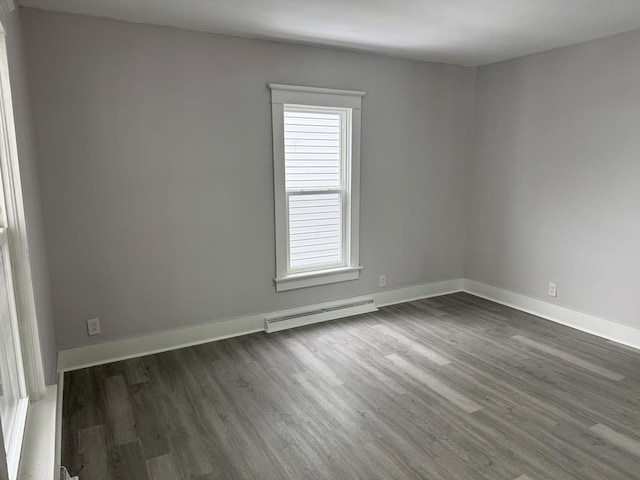 empty room featuring dark wood-type flooring and a baseboard radiator