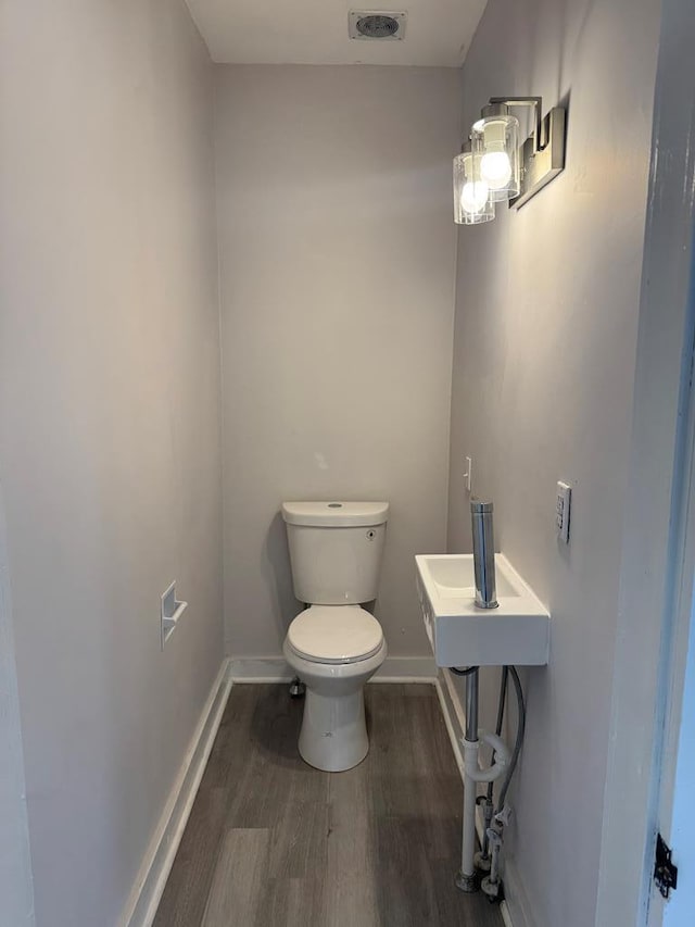 bathroom featuring wood-type flooring and toilet