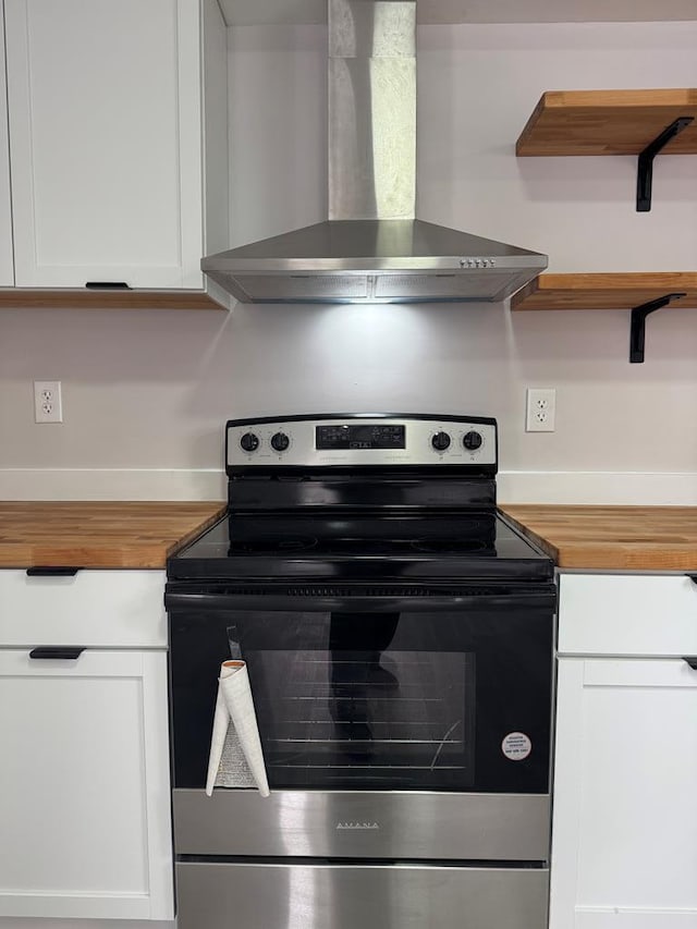 kitchen featuring electric stove, white cabinets, and wall chimney exhaust hood