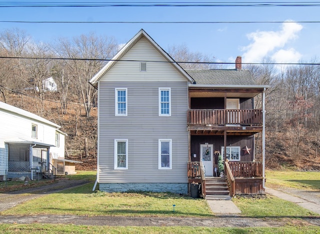 view of front property featuring a front yard and a balcony