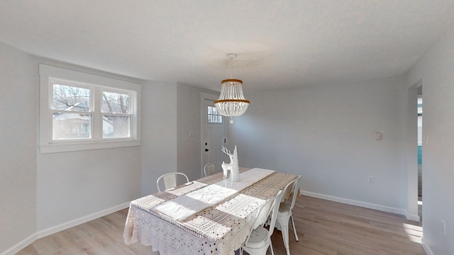 dining area featuring light wood-type flooring and an inviting chandelier