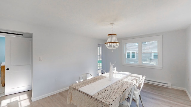 dining area featuring a baseboard radiator, an inviting chandelier, and light hardwood / wood-style floors