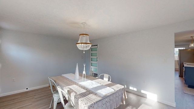 dining room featuring light wood-type flooring and an inviting chandelier