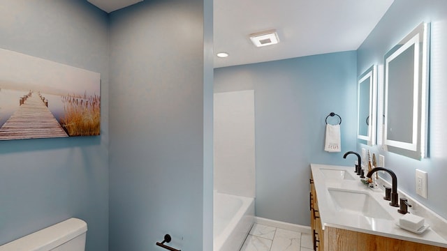 bathroom featuring vanity, toilet, and a tub to relax in