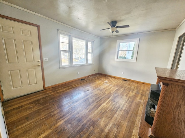 interior space featuring dark hardwood / wood-style floors, ceiling fan, and ornamental molding