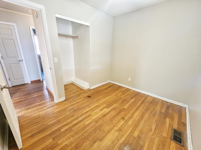 unfurnished bedroom featuring hardwood / wood-style floors and a closet