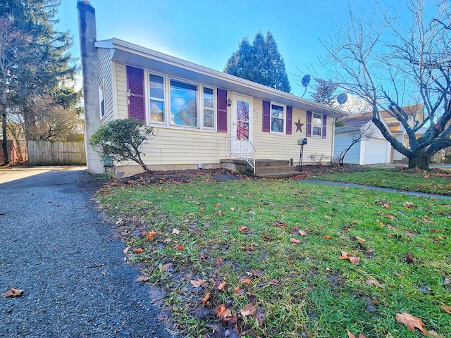 ranch-style home with an outbuilding, a front yard, and a garage