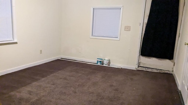 spare room featuring dark carpet