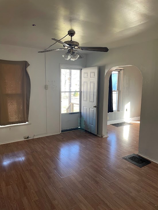 empty room with dark hardwood / wood-style floors and ceiling fan