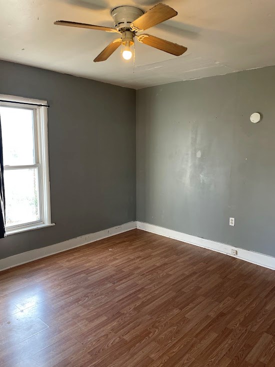 empty room with hardwood / wood-style floors and ceiling fan