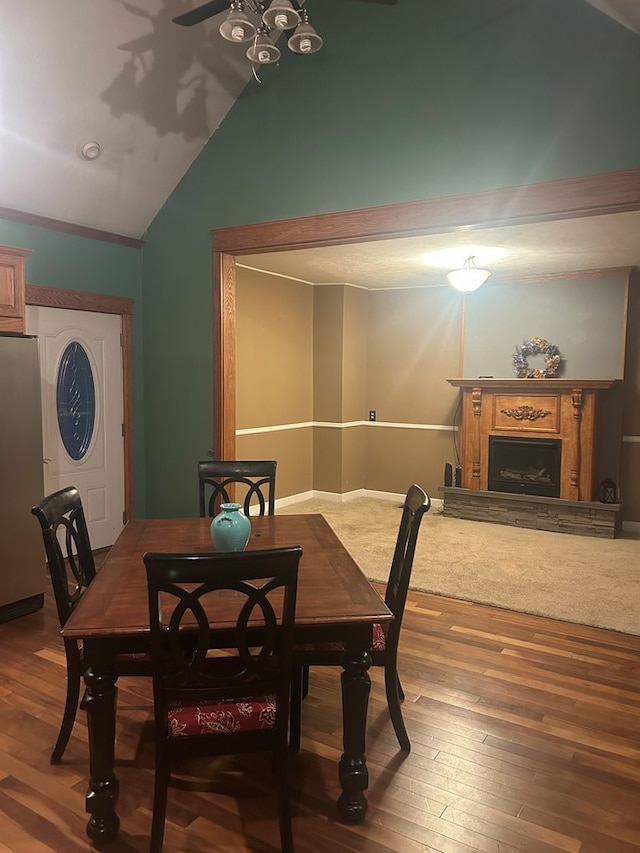 dining space featuring wood-type flooring and vaulted ceiling