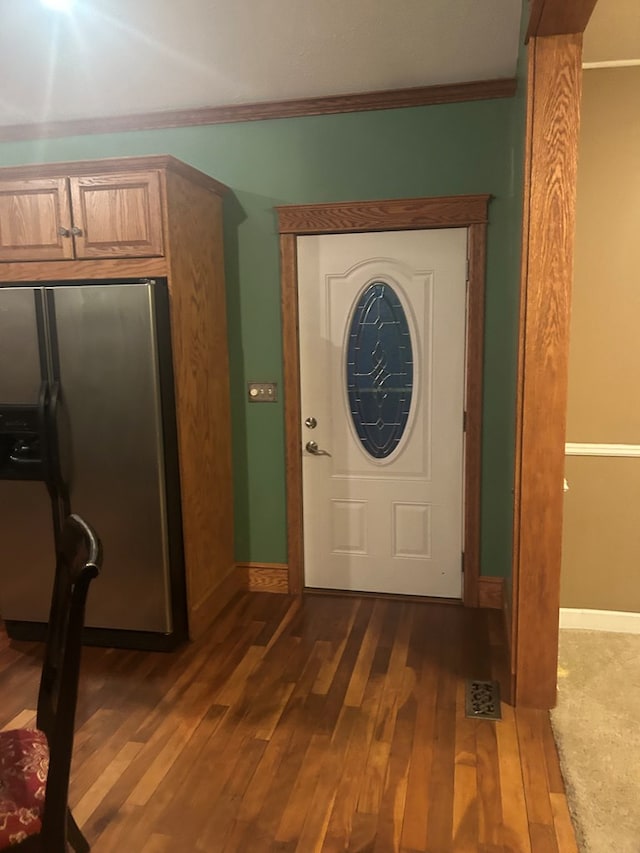 foyer entrance featuring dark wood-type flooring and ornamental molding