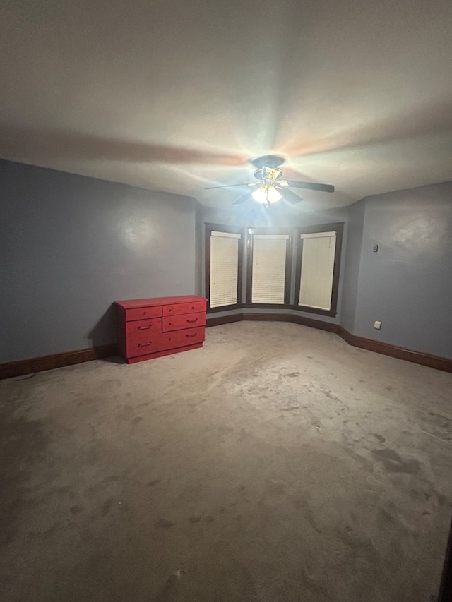 unfurnished room featuring ceiling fan and carpet