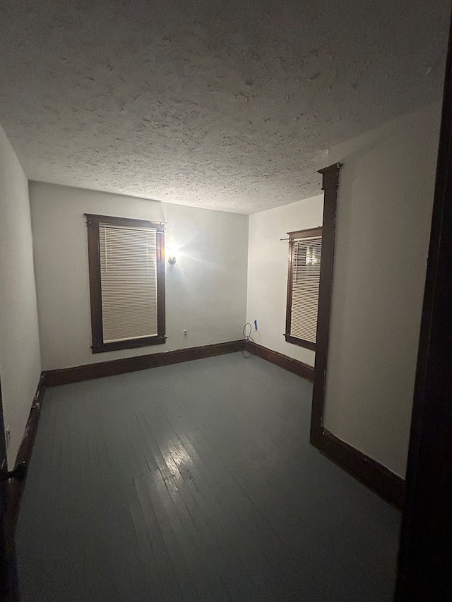 unfurnished room featuring hardwood / wood-style floors and a textured ceiling