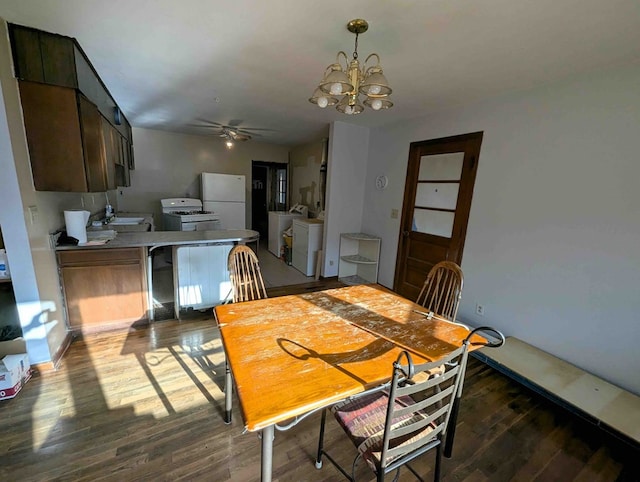 dining space featuring washer and clothes dryer, ceiling fan with notable chandelier, and dark wood-type flooring