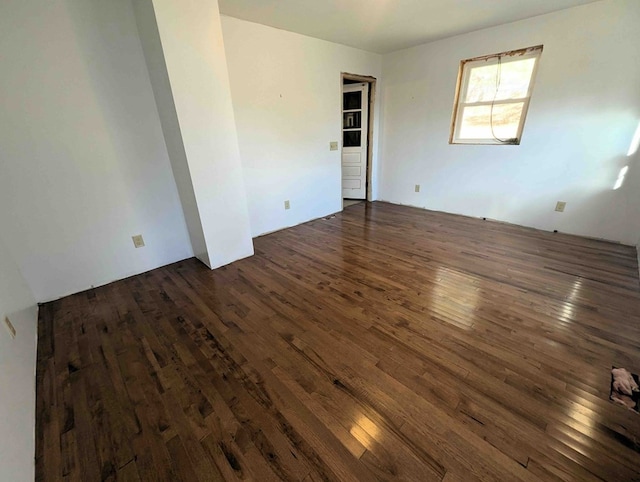 unfurnished room with dark wood-type flooring