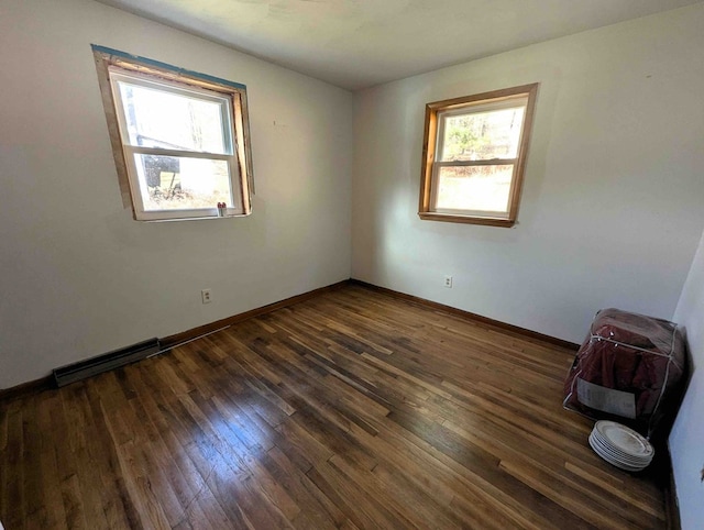 empty room with a wealth of natural light and dark hardwood / wood-style floors