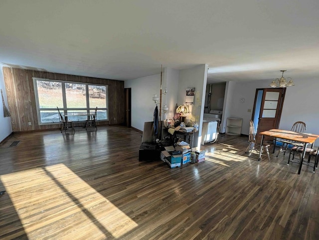 living room featuring a chandelier, dark hardwood / wood-style floors, and wood walls