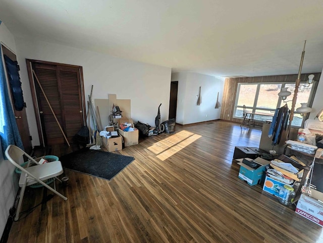 living room featuring an inviting chandelier and dark wood-type flooring