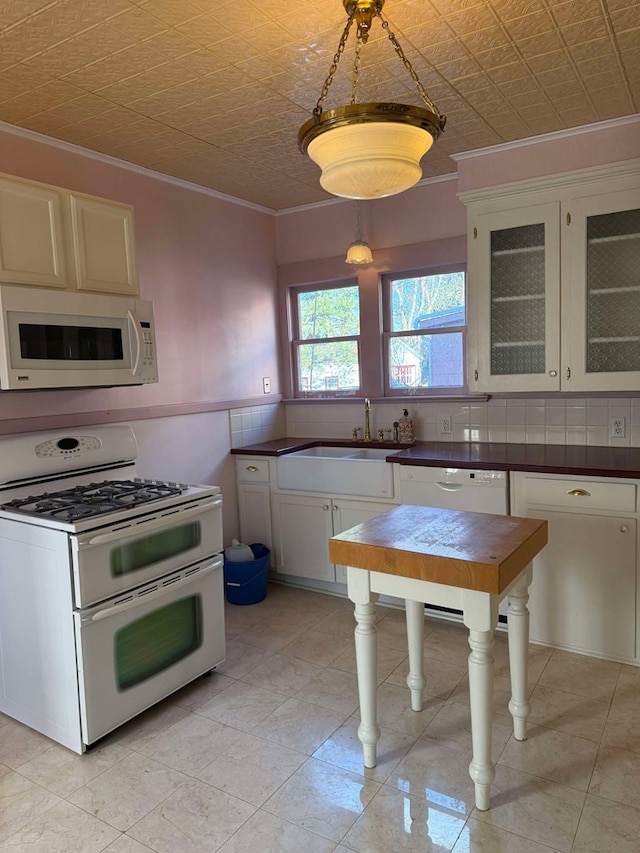 kitchen with crown molding, sink, white cabinets, and white appliances