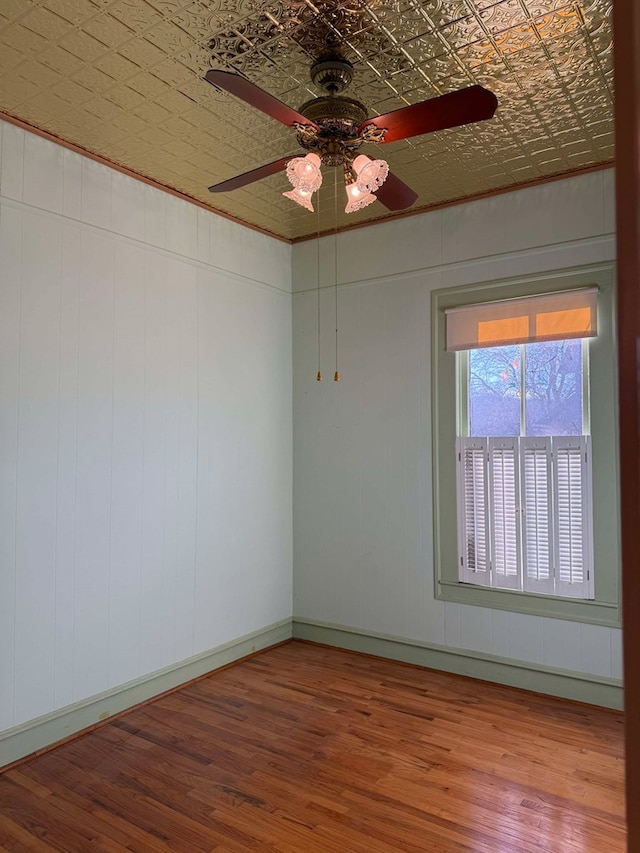 spare room with hardwood / wood-style flooring, ceiling fan, and ornamental molding