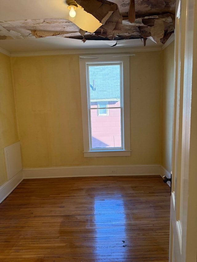 unfurnished room with wood-type flooring and ornamental molding