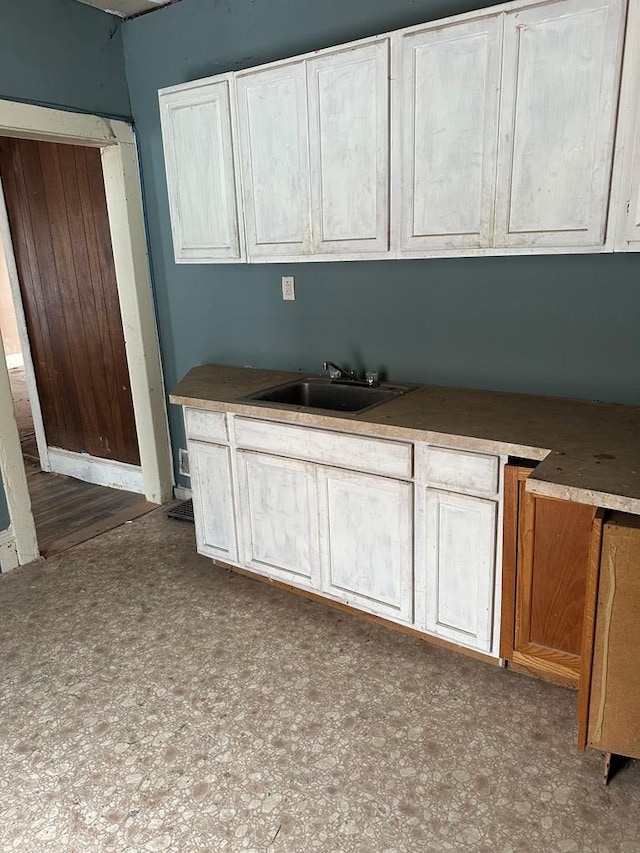 kitchen featuring dark floors and a sink