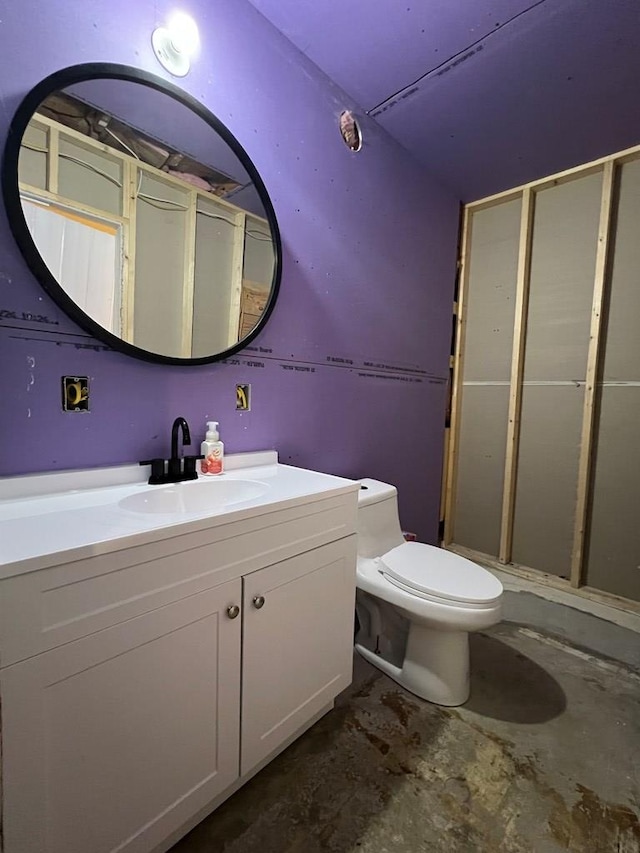 bathroom with vanity, concrete floors, and toilet