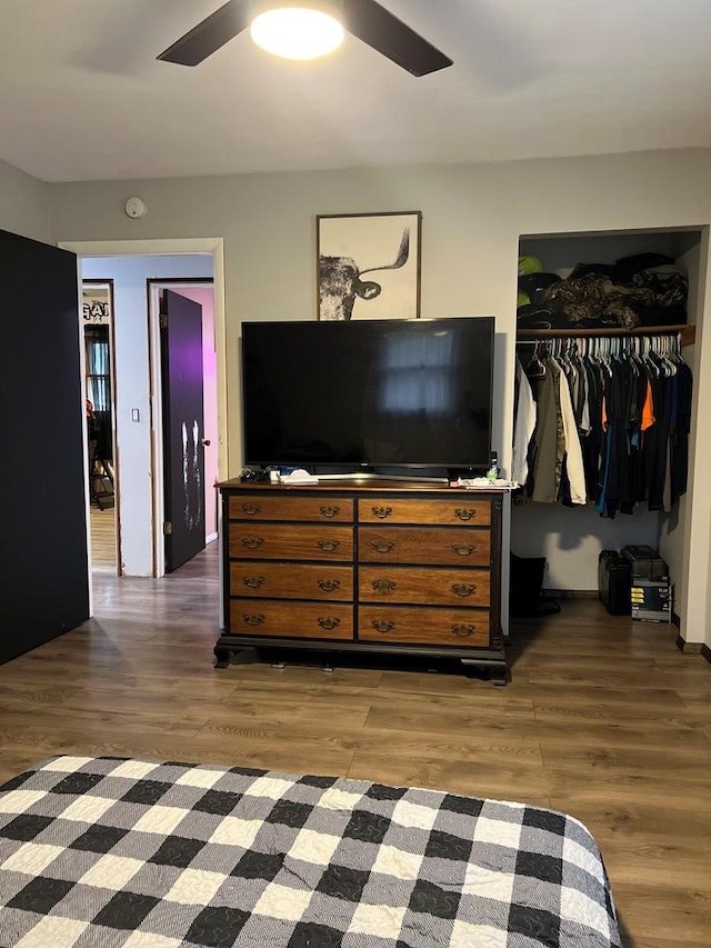 bedroom with dark hardwood / wood-style flooring, a closet, and ceiling fan