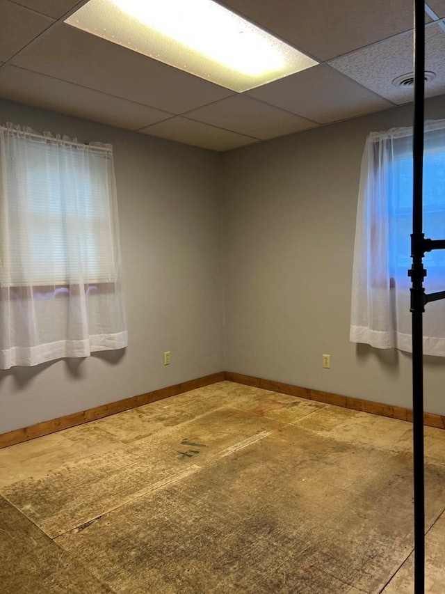 carpeted spare room featuring a paneled ceiling