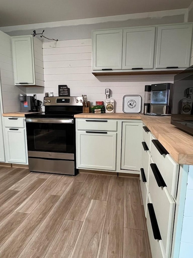 kitchen featuring stainless steel electric stove, light hardwood / wood-style flooring, white cabinets, and wooden counters