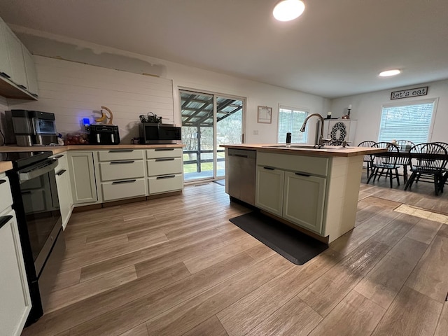 kitchen featuring a healthy amount of sunlight, sink, light hardwood / wood-style floors, and appliances with stainless steel finishes