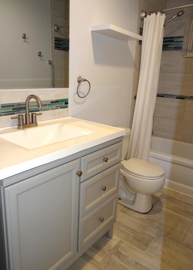 full bathroom with tasteful backsplash, shower / tub combo with curtain, vanity, and toilet