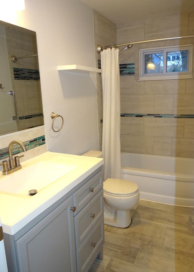 full bathroom featuring decorative backsplash, vanity, toilet, and shower / bathtub combination with curtain