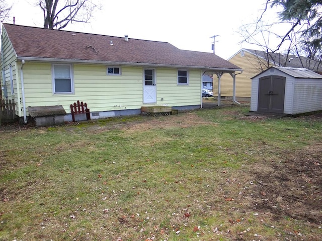 rear view of property featuring a lawn and a storage shed