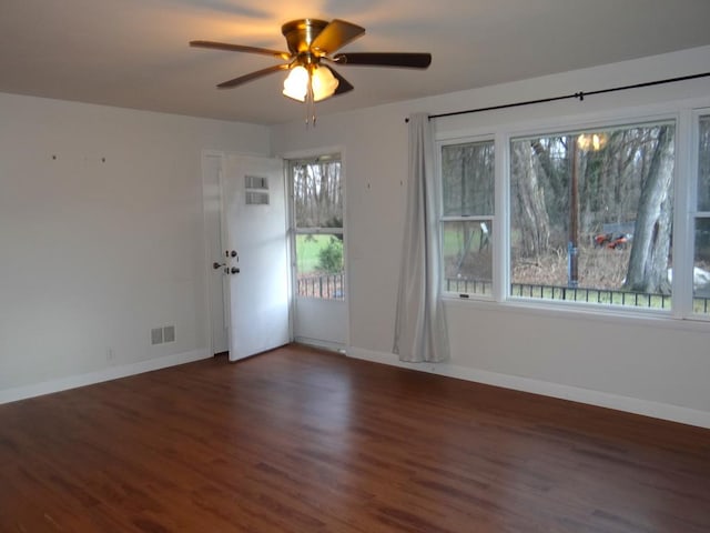 unfurnished room with a wealth of natural light, ceiling fan, and dark hardwood / wood-style flooring