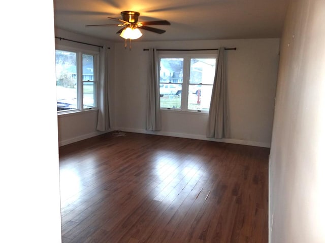 unfurnished room with ceiling fan and dark wood-type flooring