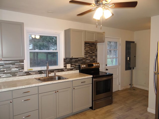 kitchen with decorative backsplash, ceiling fan, sink, electric stove, and gray cabinets