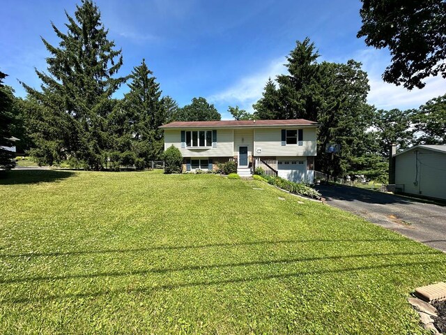 bi-level home featuring a garage and a front lawn